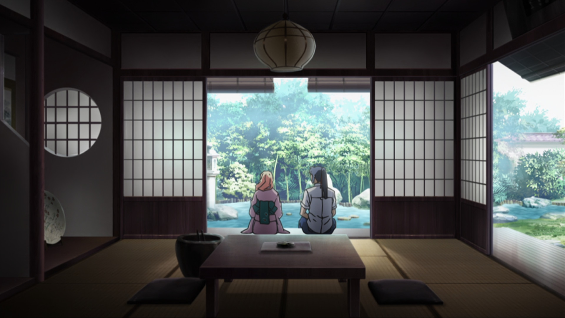 Alto and Sheryl sitting in Japanese room with doors slid open to pond garden